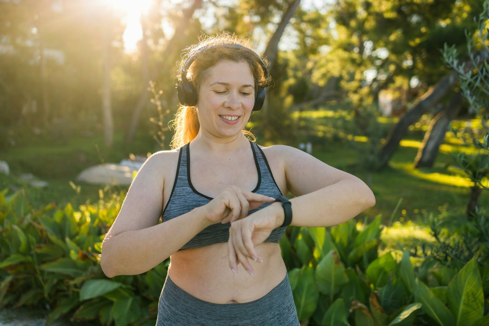 Fat woman checking time or heart rate from smart watch. Exercise or running outdoors for weight loss